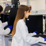 Two academic researchers review experimental data on computers in a university laboratory.