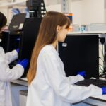 Two laboratory scientists review imaging data at computer workstations.