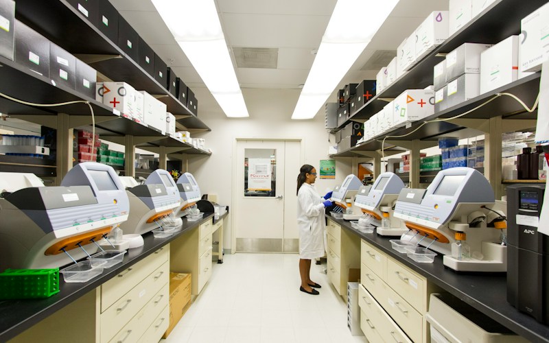 A laboratory technician working among genomic sequencing instruments